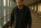 A traveler walks through a quiet airport terminal at sunset, carrying a small bag and boarding pass, symbolizing urgency and reflection during bereavement fare travel.