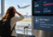 Traveler at an airport watching a departed flight, illustrating how missing an outbound flight can affect the remaining itinerary and return flight.